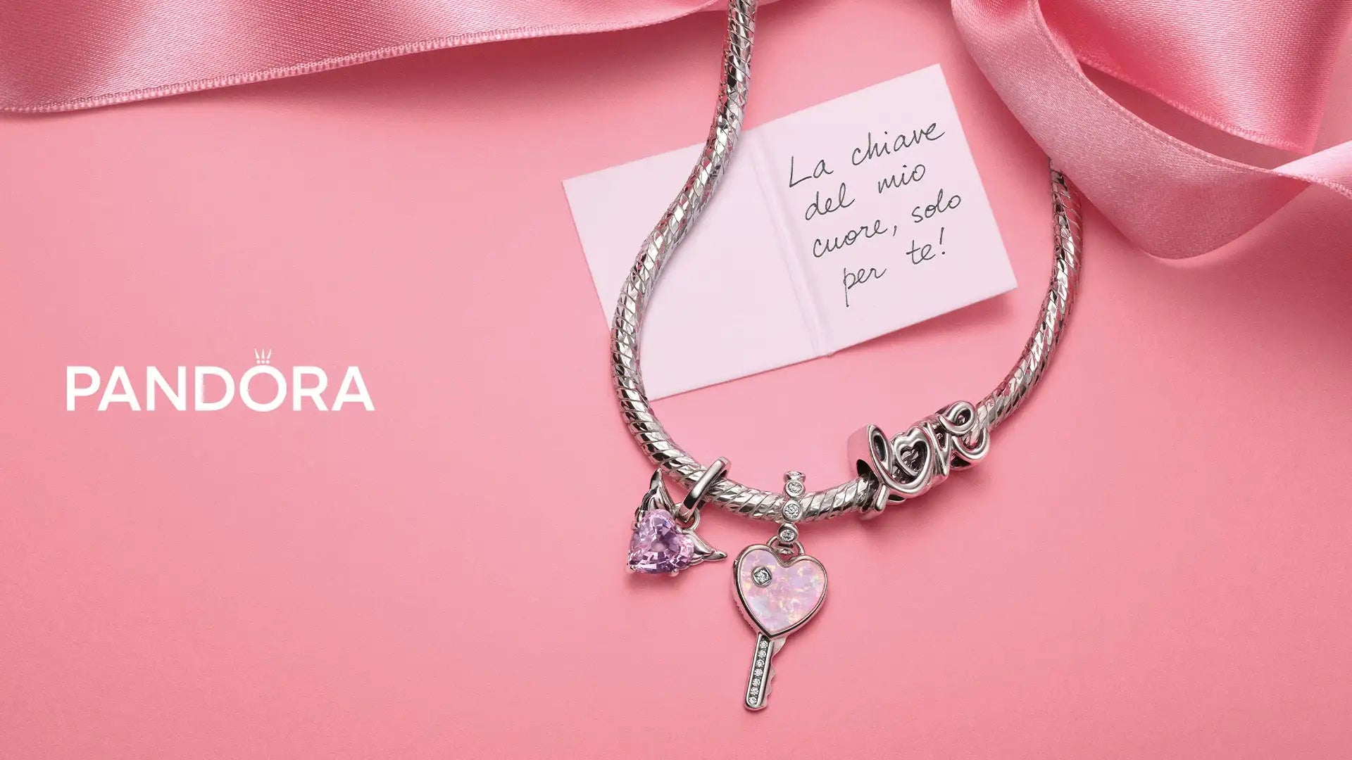 Braccialetto con charm Pandora in argento ornato con un medaglione a forma di cuore, un ciondolo con gemma viola e un charm inciso 'love'.
